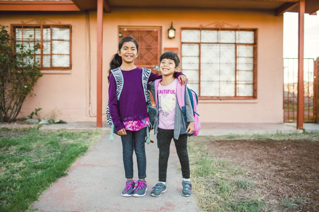 Girls Giggling in Front Yard of Their Home