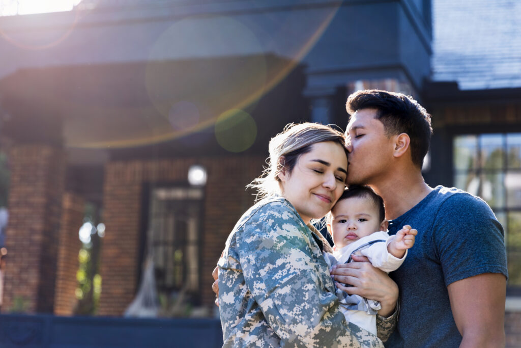 latino family in front of house.